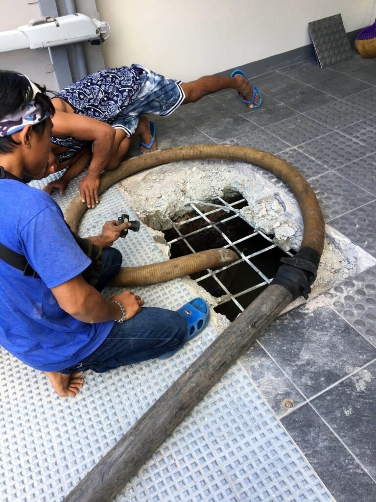 JA Torres crew opening a septic tank grate to start siphoning
