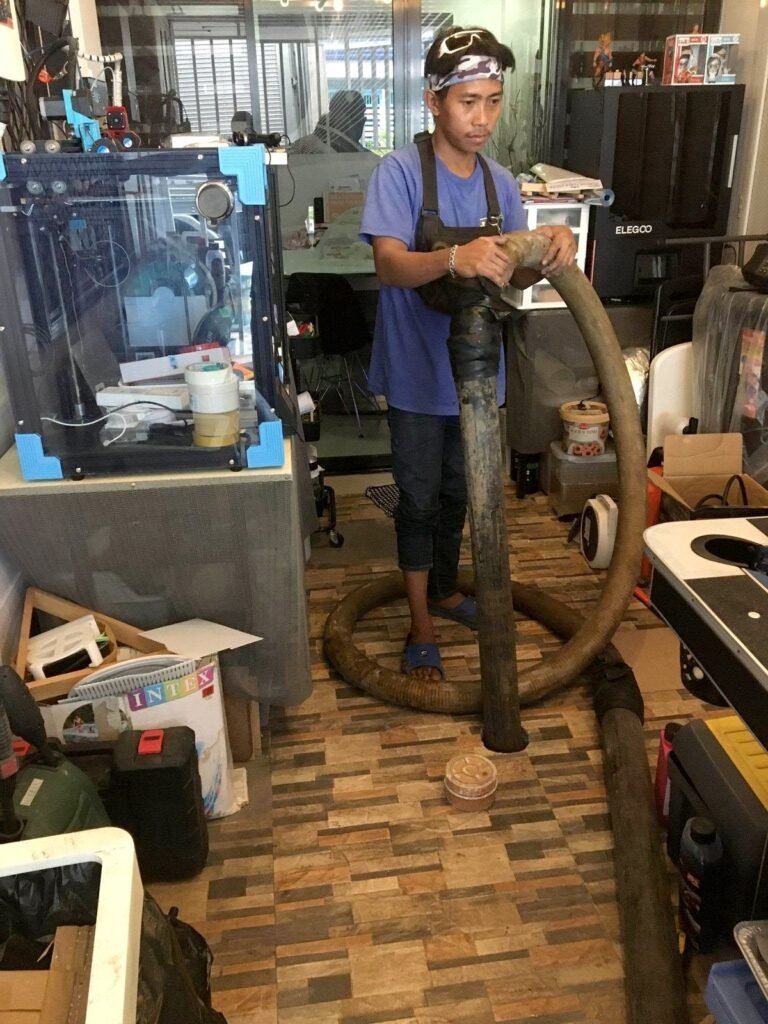 JA Torres crew member siphoning a septic tank inside an office