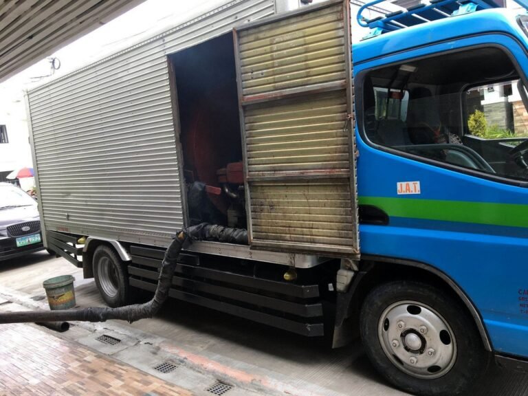 JA Torres Malabanan siphoning truck with vacuum hose connected, parked at a job site