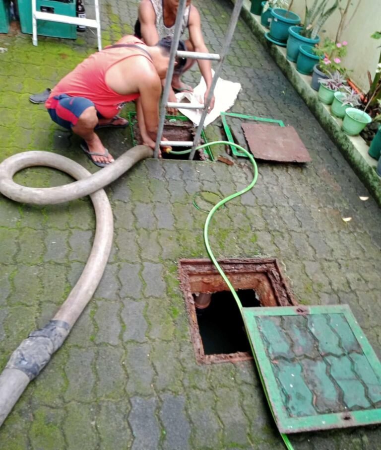 Septic tank siphoning through a garden manhole with the cover removed
