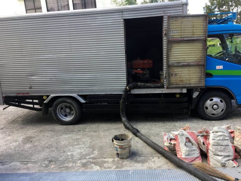 JA Torres siphoning truck with hose running to the septic tank